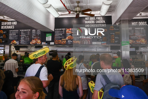 People are buying hot dogs during Nathan's Famous Hot Dogs Eating Contest which takes place annually at Coney Island on Independence Day in...