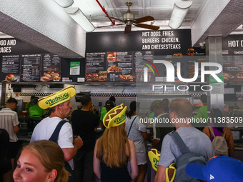 People are buying hot dogs during Nathan's Famous Hot Dogs Eating Contest which takes place annually at Coney Island on Independence Day in...