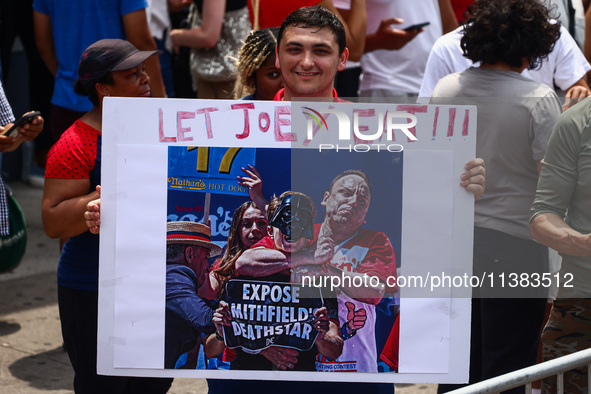 A person holds a banner standing for Joey Chestnut during Nathan's Famous Hot Dogs Eating Contest which takes place annually at Coney Island...