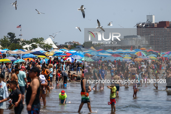 Crowds of people enjoy the beach at Coney Island Beach on Independence Day in New York, United States of America on July 4th, 2024.
 