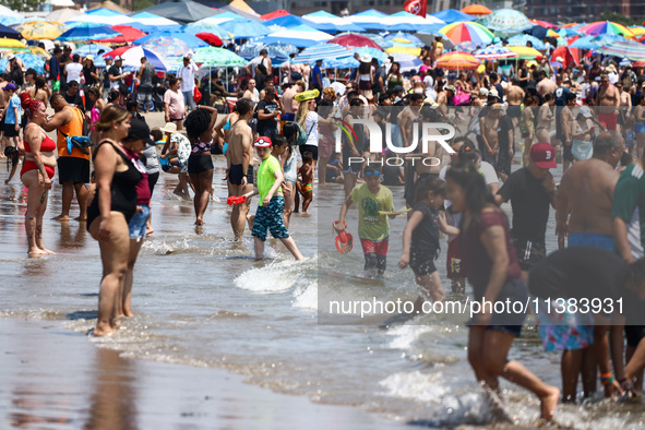 Crowds of people enjoy the beach at Coney Island Beach on Independence Day in New York, United States of America on July 4th, 2024.
 