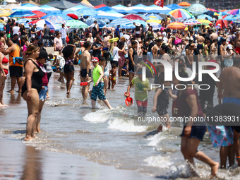 Crowds of people enjoy the beach at Coney Island Beach on Independence Day in New York, United States of America on July 4th, 2024.
 (