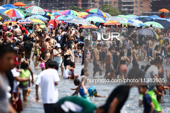 Crowds of people enjoy the beach at Coney Island Beach on Independence Day in New York, United States of America on July 4th, 2024.
 