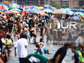 Crowds of people enjoy the beach at Coney Island Beach on Independence Day in New York, United States of America on July 4th, 2024.
 (