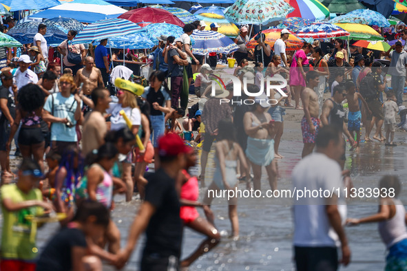 Crowds of people enjoy the beach at Coney Island Beach on Independence Day in New York, United States of America on July 4th, 2024.
 