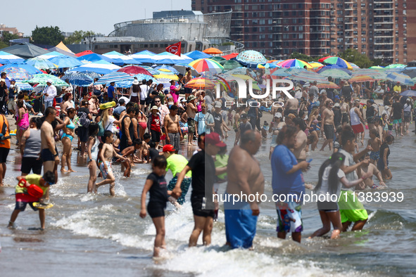 Crowds of people enjoy the beach at Coney Island Beach on Independence Day in New York, United States of America on July 4th, 2024.
 