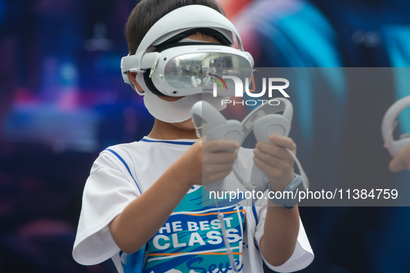 A young visitor is playing games with a Virtual Reality headset at the World Artificial Intelligence Conference at the Shanghai World Expo E...