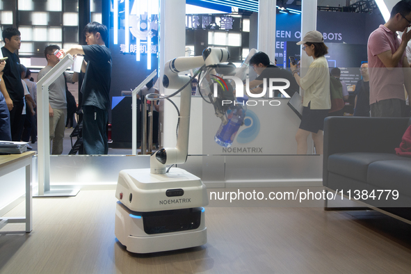 A robot is picking up a bottle of water from the floor at the World Artificial Intelligence Conference at the Shanghai World Expo Exhibition...