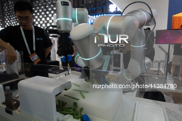 A robot is slicing vegetables at the World Artificial Intelligence Conference at the Shanghai World Expo Exhibition Center in Shanghai, Chin...