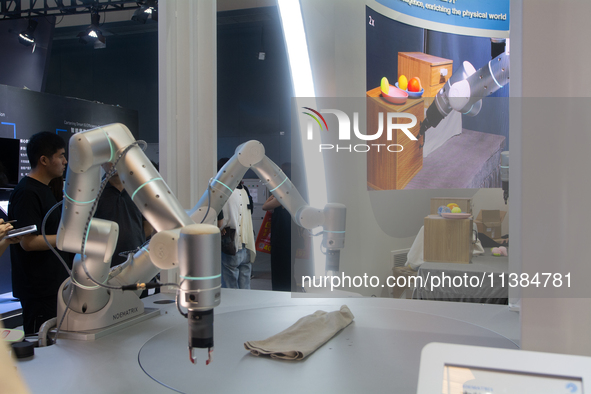 A robot is folding clothing at the World Artificial Intelligence Conference at the Shanghai World Expo Exhibition Center in Shanghai, China,...