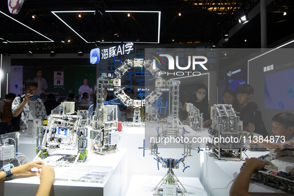 Children are playing at Hai Tun Zixi, a learning assistant AI, standing at the World Artificial Intelligence Conference at the Shanghai Worl...