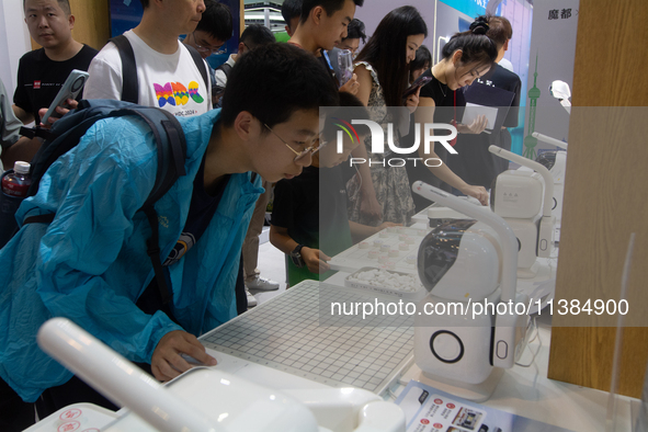 Visitors are playing chess with robots at the World Artificial Intelligence Conference at the Shanghai World Expo Exhibition Center in Shang...