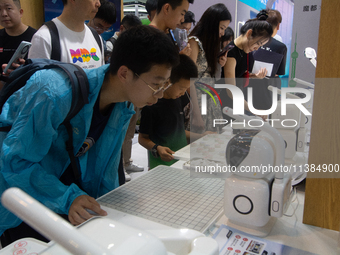 Visitors are playing chess with robots at the World Artificial Intelligence Conference at the Shanghai World Expo Exhibition Center in Shang...