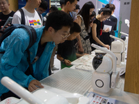 Visitors are playing chess with robots at the World Artificial Intelligence Conference at the Shanghai World Expo Exhibition Center in Shang...