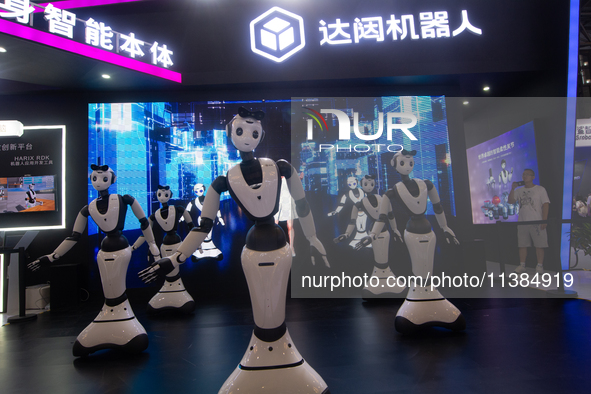 Several humanoid robots are performing dance movements at the World Artificial Intelligence Conference at the Shanghai World Expo Exhibition...