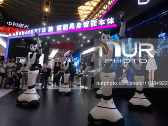 Several humanoid robots are performing dance movements at the World Artificial Intelligence Conference at the Shanghai World Expo Exhibition...