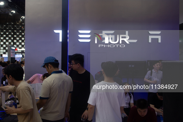 Visitors are being seen at the Tesla stand at the World Artificial Intelligence Conference at the Shanghai World Expo Exhibition Center in S...