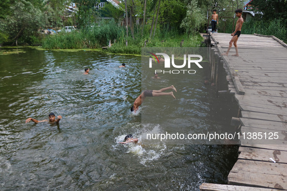 A boy is taking a dip into the waters of Dal Lake to cool off on a hot summer day in Srinagar, Jammu And Kashmir, on July 05, 2024. 