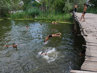 A boy is taking a dip into the waters of Dal Lake to cool off on a hot summer day in Srinagar, Jammu And Kashmir, on July 05, 2024. (