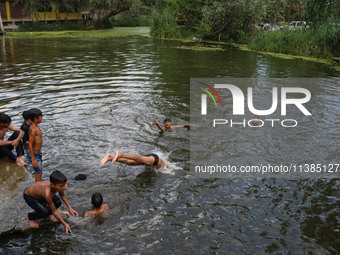 Kashmiri boys are taking a bath in the waters of Dal Lake to cool off on a hot summer day in Srinagar, Jammu And Kashmir, on July 05, 2024....