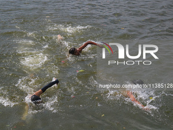 Kashmiri boys are swimming in the waters of Dal Lake to cool off on a hot summer day in Srinagar, Jammu And Kashmir, on July 05, 2024. (