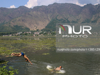 A boy is taking a dip into the waters of Dal Lake to cool off on a hot summer day in Srinagar, Jammu And Kashmir, on July 05, 2024. (