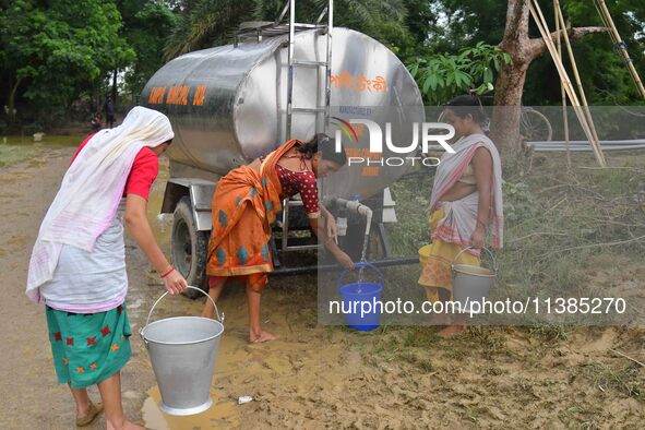 Flood-affected villagers are collecting drinking water from a relief camp conducted by the Public Health Centre (PHC) near Kampur in Nagaon...