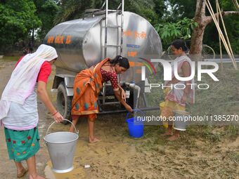 Flood-affected villagers are collecting drinking water from a relief camp conducted by the Public Health Centre (PHC) near Kampur in Nagaon...