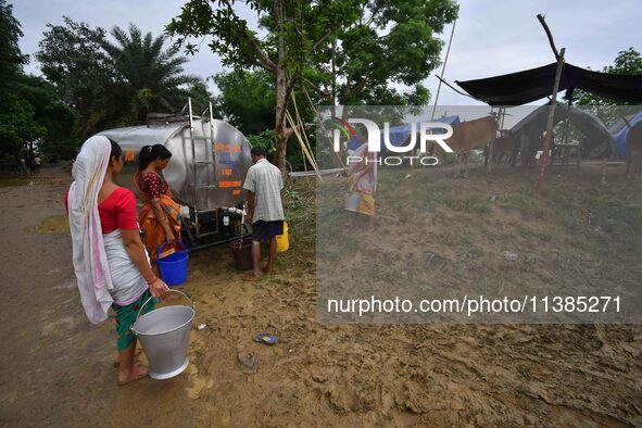 Flood-affected villagers are collecting drinking water from a relief camp conducted by the Public Health Centre (PHC) near Kampur in Nagaon...