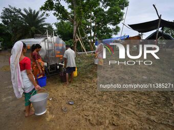 Flood-affected villagers are collecting drinking water from a relief camp conducted by the Public Health Centre (PHC) near Kampur in Nagaon...