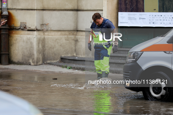 Emergency water supply is being provided during flooding due to a water mains failure near the former Main Post Office in Krakow, Poland, on...