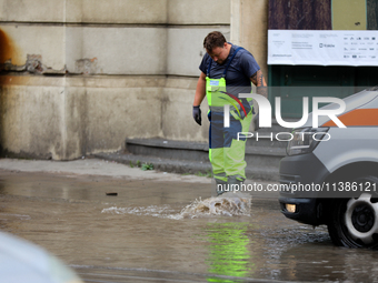 Emergency water supply is being provided during flooding due to a water mains failure near the former Main Post Office in Krakow, Poland, on...