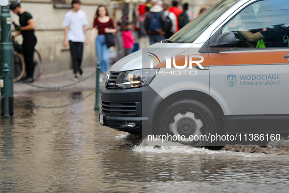 Emergency water supply is being provided during flooding due to a water mains failure near the former Main Post Office in Krakow, Poland, on...