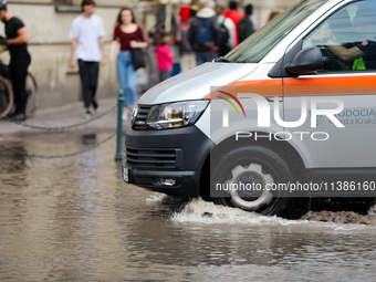 Emergency water supply is being provided during flooding due to a water mains failure near the former Main Post Office in Krakow, Poland, on...