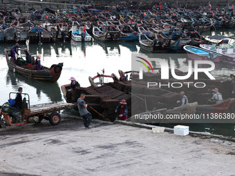 Fishermen are transferring abalone cages from their fishing boat to shore at Songluwan Pier in Fuzhou, Fujian province, China, on July 5, 20...