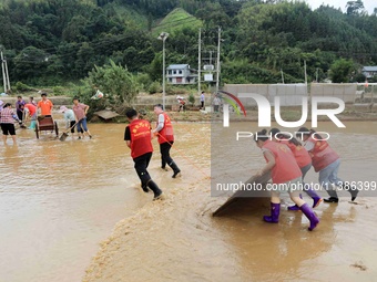 Volunteers are cleaning up silt in Si 'an village, Rongan county, Liuzhou city, South China's Guangxi Zhuang Autonomous region, in Liuzhou,...