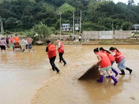 Volunteers are cleaning up silt in Si 'an village, Rongan county, Liuzhou city, South China's Guangxi Zhuang Autonomous region, in Liuzhou,...