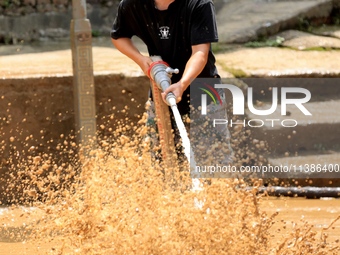 A worker is washing silt in Si 'an village, Rongan county, Liuzhou city, South China's Guangxi Zhuang Autonomous region, in Liuzhou, China,...