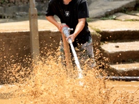 A worker is washing silt in Si 'an village, Rongan county, Liuzhou city, South China's Guangxi Zhuang Autonomous region, in Liuzhou, China,...