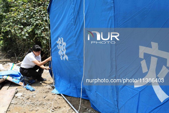 Volunteers are setting up tents for disaster-hit villagers in Si 'an village, Rongan county, Liuzhou city, South China's Guangxi Zhuang Auto...