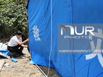 Volunteers are setting up tents for disaster-hit villagers in Si 'an village, Rongan county, Liuzhou city, South China's Guangxi Zhuang Auto...