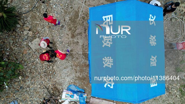 Volunteers are setting up tents for disaster-hit villagers in Si 'an village, Rongan county, Liuzhou city, South China's Guangxi Zhuang Auto...