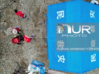 Volunteers are setting up tents for disaster-hit villagers in Si 'an village, Rongan county, Liuzhou city, South China's Guangxi Zhuang Auto...