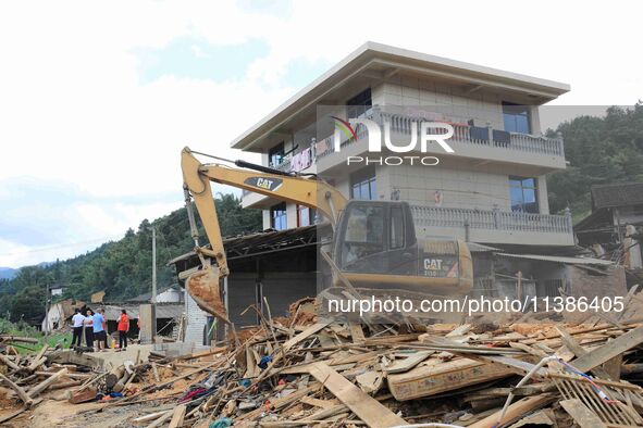 Workers are cleaning up collapsed houses in Si'an village, Rongan county, Liuzhou city, South China's Guangxi Zhuang Autonomous region, in L...