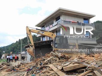 Workers are cleaning up collapsed houses in Si'an village, Rongan county, Liuzhou city, South China's Guangxi Zhuang Autonomous region, in L...