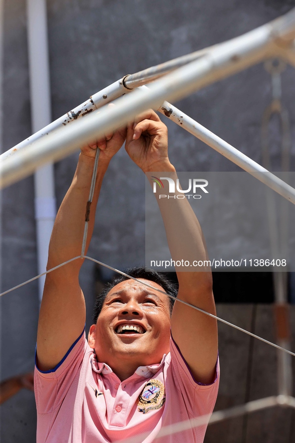 A worker is setting up tents for villagers in Si'an village, Rongan county, Liuzhou, China, on July 5, 2024. 