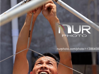 A worker is setting up tents for villagers in Si'an village, Rongan county, Liuzhou, China, on July 5, 2024. (