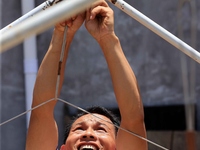 A worker is setting up tents for villagers in Si'an village, Rongan county, Liuzhou, China, on July 5, 2024. (