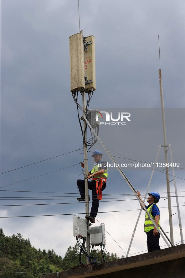 A staff member is repairing a damaged communication base station in Si 'an village, Rongan county, Liuzhou city, South China's Guangxi Zhuan...