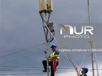 A staff member is repairing a damaged communication base station in Si 'an village, Rongan county, Liuzhou city, South China's Guangxi Zhuan...